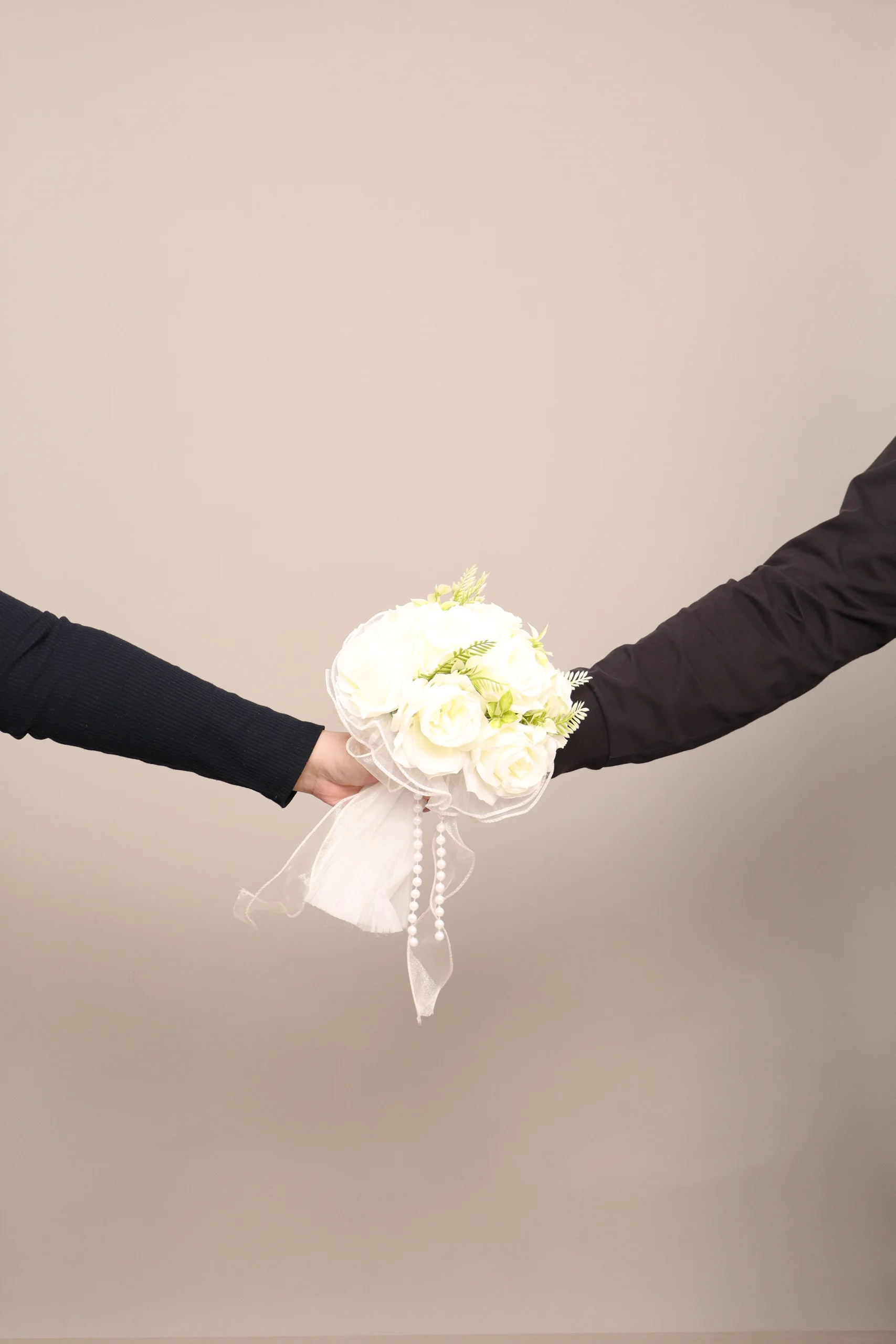 Mario and Inah holding a white bouquet between their outstretched arms