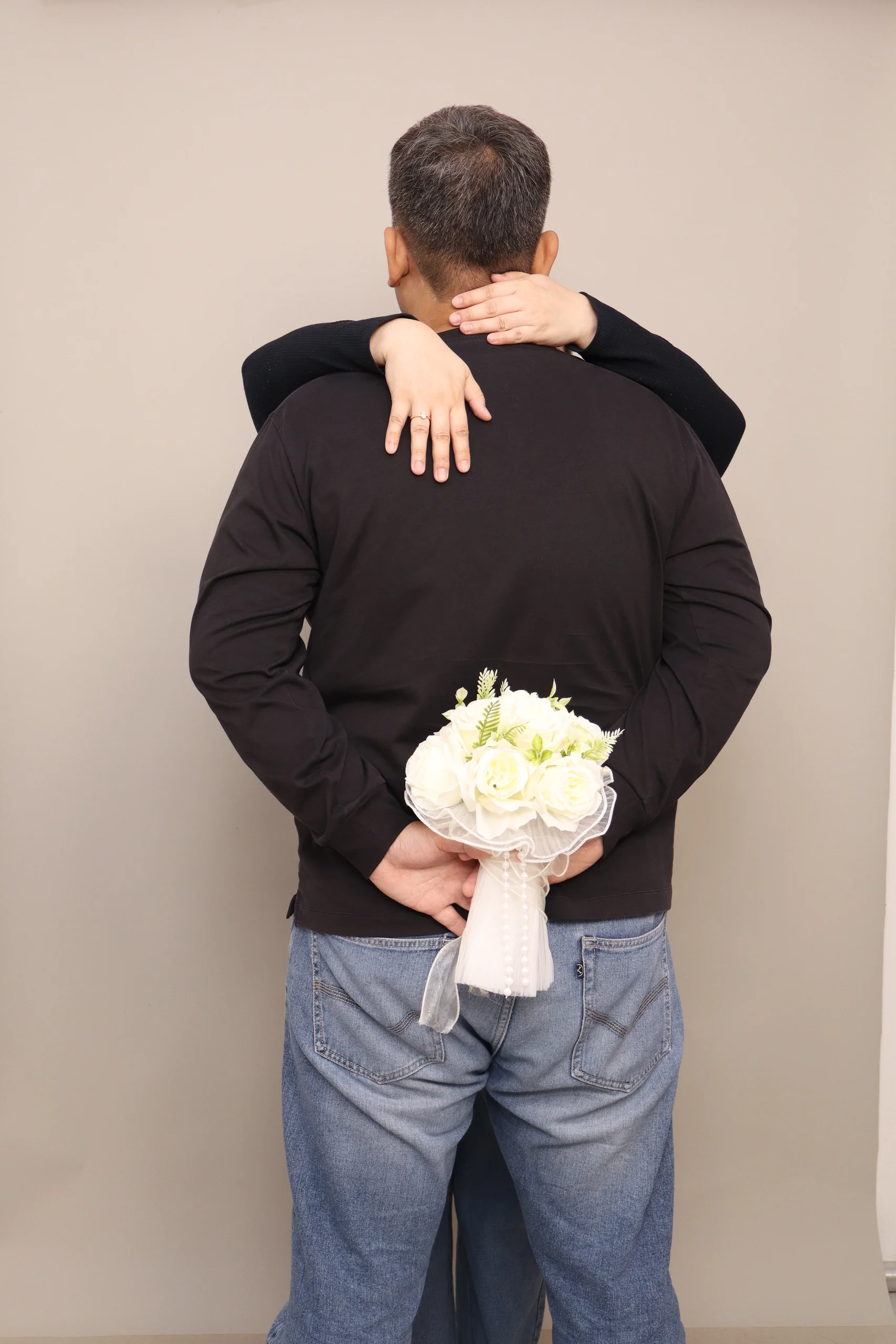 Inah embracing Mario with a bouquet behind his back